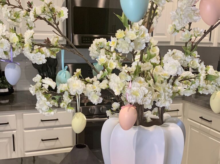 White vase with Cherry Blossoms and Easter Egg Ornaments for an Easter Centerpiece